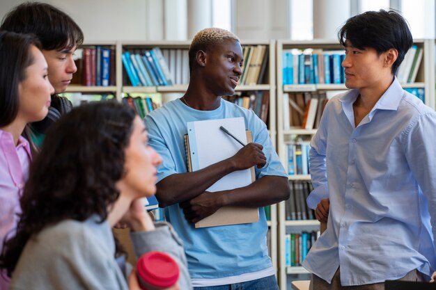 Vue latérale des étudiants discutant dans la bibliothèque