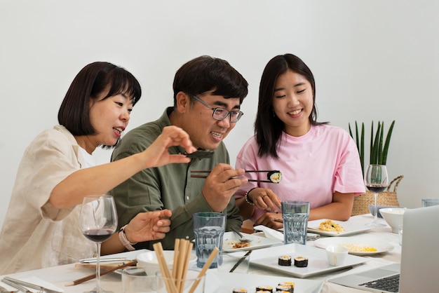 Vue latérale famille asiatique manger ensemble