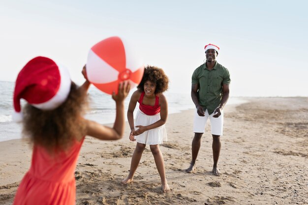 Vue latérale famille heureuse jouant avec ballon