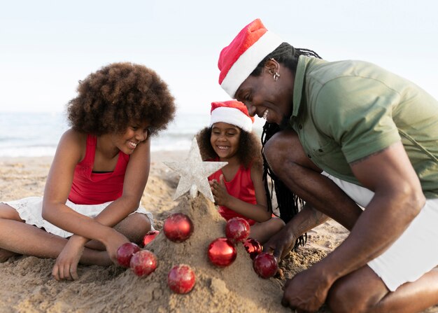 Vue latérale famille heureuse à la plage avec étoile dorée