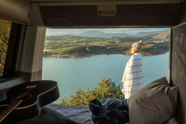 Vue latérale d'une femme admirant la nature lors d'un road trip