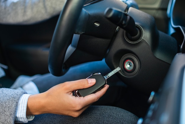 Vue latérale d'une femme d'affaires à l'aide de touches pour allumer la voiture