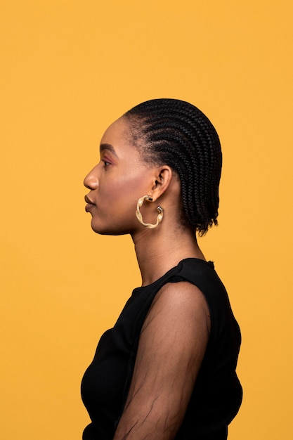 Vue latérale femme africaine avec boucles d'oreilles dorées