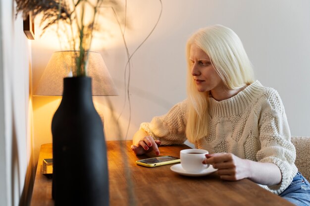 Vue latérale femme albinos assise à table
