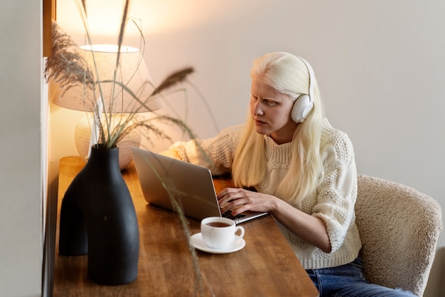 Photo gratuite vue latérale femme albinos travaillant sur ordinateur portable