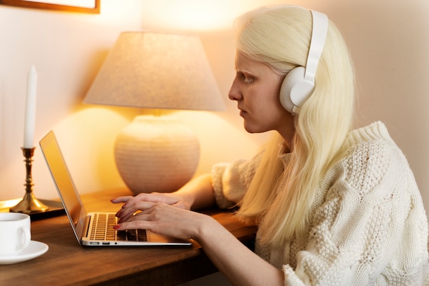 Vue latérale femme albinos travaillant sur ordinateur portable