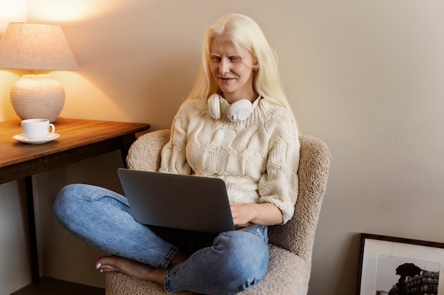 Vue latérale femme albinos travaillant sur ordinateur portable