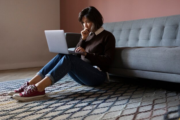 Vue latérale femme anxieuse tenant un ordinateur portable