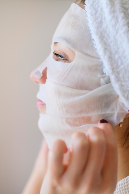 Vue latérale d'une femme appliquant un masque facial