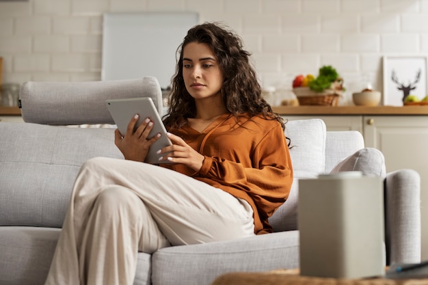 Vue latérale femme assise sur le canapé