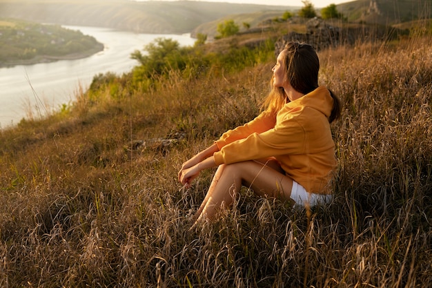 Photo gratuite vue latérale femme assise à l'extérieur