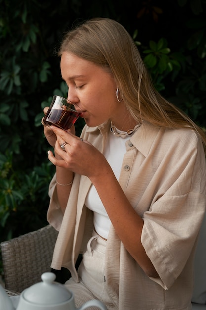 Photo gratuite vue latérale femme buvant du thé à l'extérieur