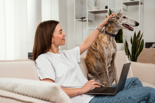 Photo gratuite vue latérale femme caressant un chien mignon