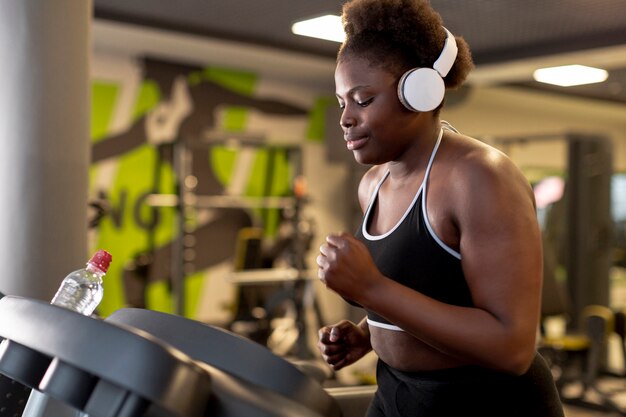 Vue latérale femme avec un casque en cours d'exécution