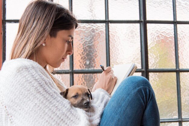 Vue latérale femme avec chien et stylo