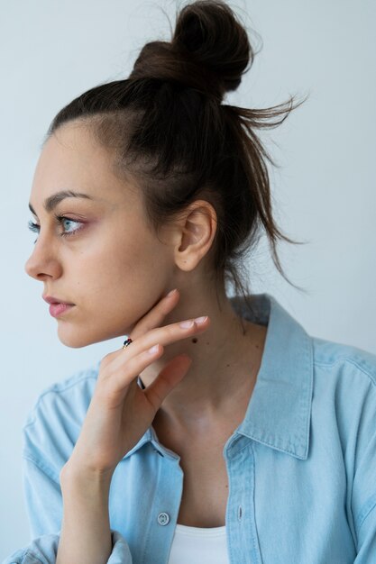 Vue latérale femme avec chignon désordonné posant