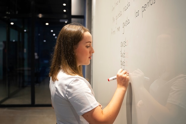 Photo gratuite vue latérale femme corrigeant les erreurs de grammaire