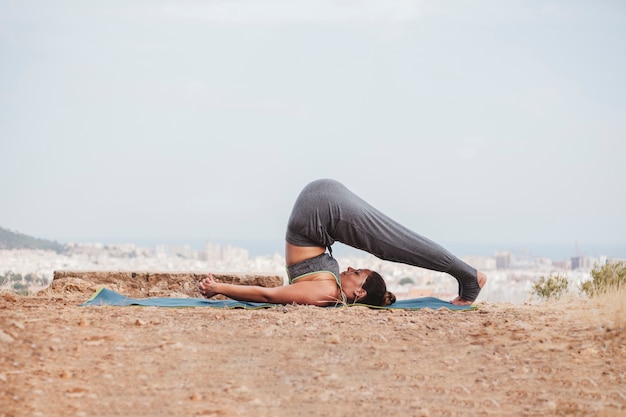 Vue latérale de la femme dans la posture de yoga