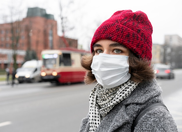 Vue latérale de la femme dans la ville avec masque médical