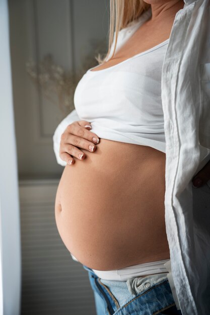 Vue latérale d'une femme enceinte passant du temps à l'intérieur