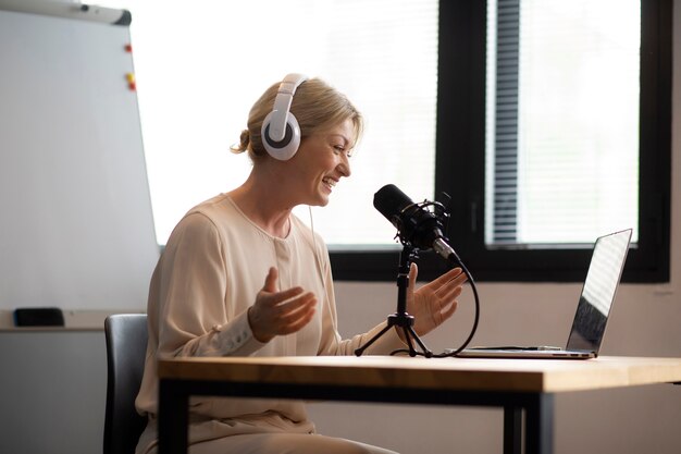 Vue latérale femme enregistrant un podcast avec un casque