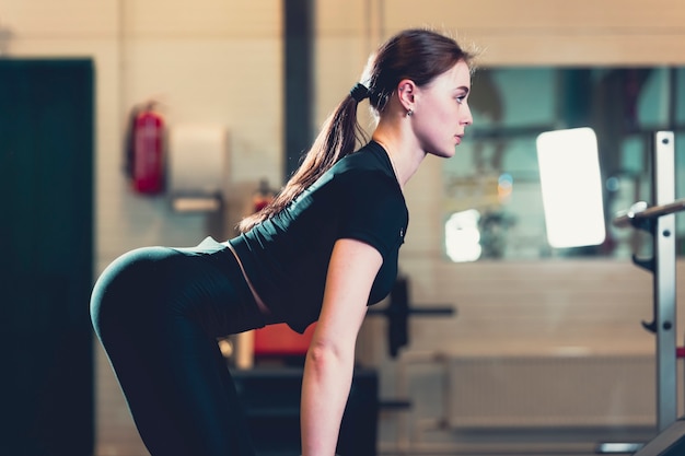 Vue latérale d&#39;une femme exerçant dans la salle de gym