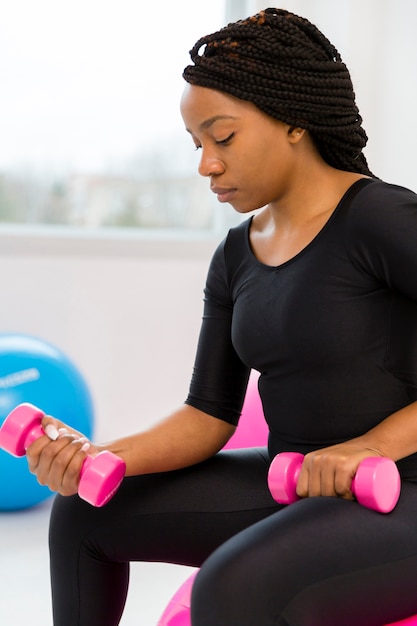 Vue latérale femme exerçant avec des poids