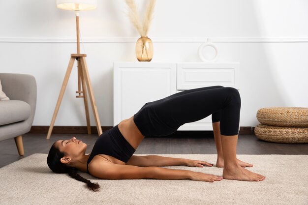 Vue latérale femme faisant de l'exercice à la maison