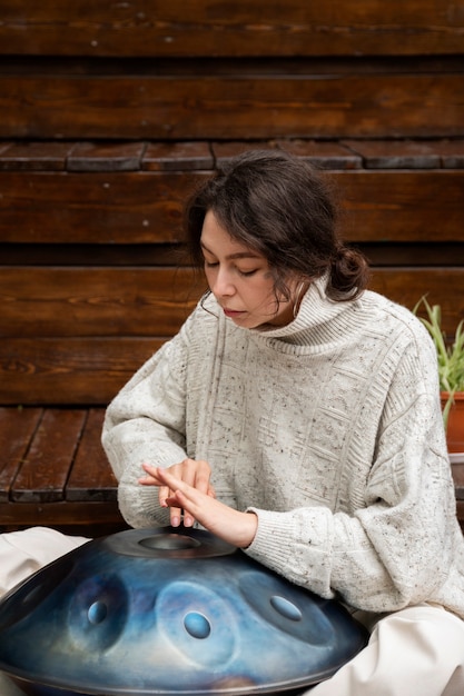 Photo gratuite vue latérale femme faisant de la musique avec handpan