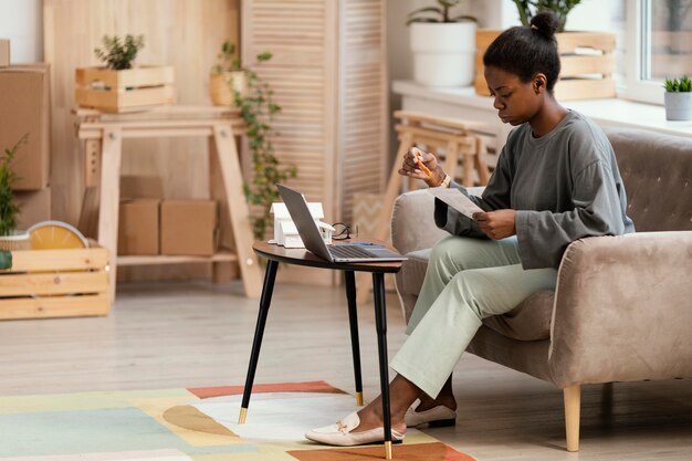 Vue latérale d'une femme faisant des plans pour redécorer la maison