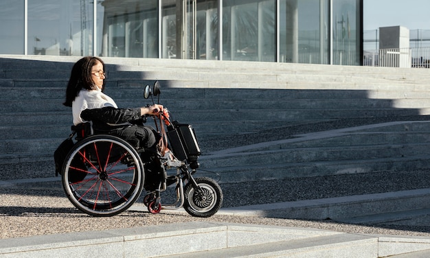 Vue latérale de la femme en fauteuil roulant dans la rue avec espace copie