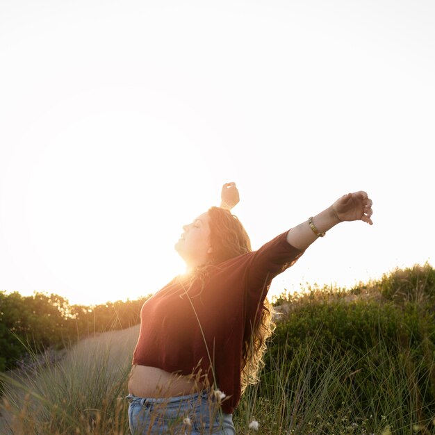 Vue latérale d'une femme insouciante heureuse dans la nature