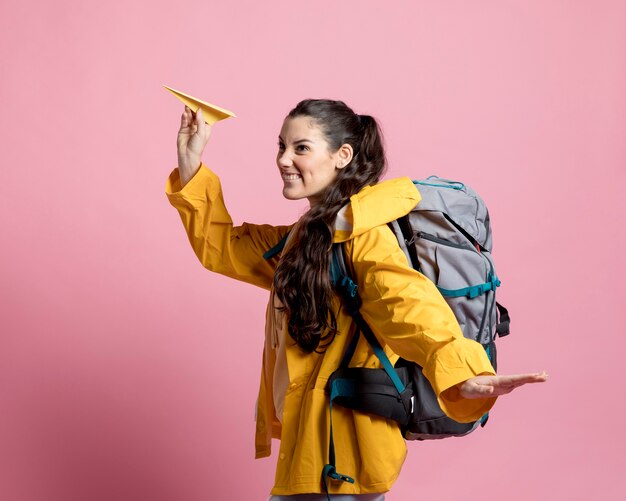 Vue latérale femme jouant avec un avion en papier