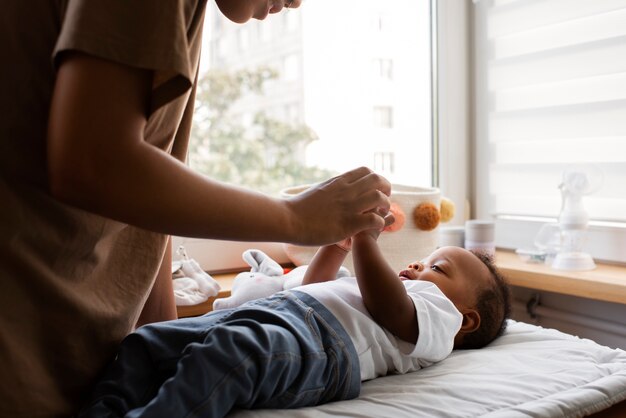 Vue latérale femme jouant avec bébé