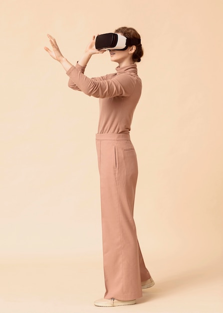 Vue latérale femme jouant sur un casque de réalité virtuelle