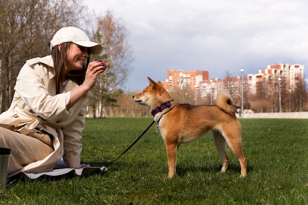 Vue latérale femme jouant avec un chien mignon