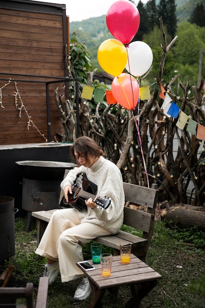 Vue latérale femme jouant de la guitare dans la nature