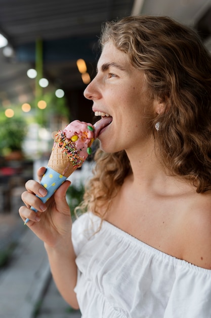 Photo gratuite vue latérale femme léchant le cornet de crème glacée