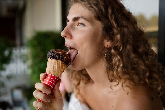 Photo gratuite vue latérale femme léchant le cornet de crème glacée