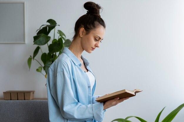 Vue latérale femme lisant à la maison