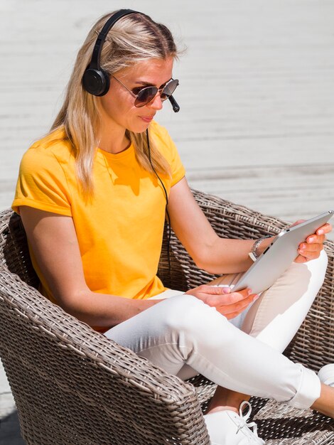 Vue latérale d'une femme avec des lunettes de soleil et un casque travaillant à la plage