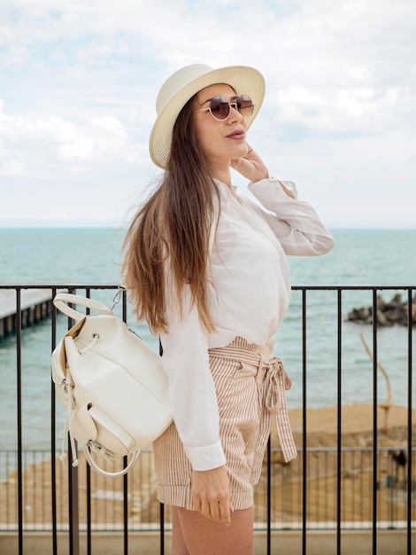 Vue latérale femme avec des lunettes de soleil