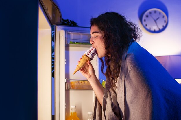 Vue latérale femme mangeant de la glace