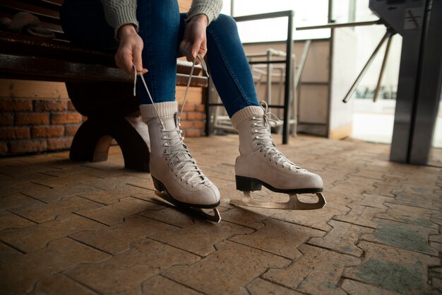 Vue latérale femme mettant des patins à glace