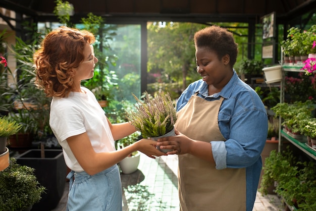 Photo gratuite vue latérale femme noire qui dirige une entreprise de fleurs