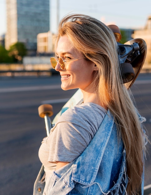 Photo gratuite vue latérale femme avec planche à roulettes