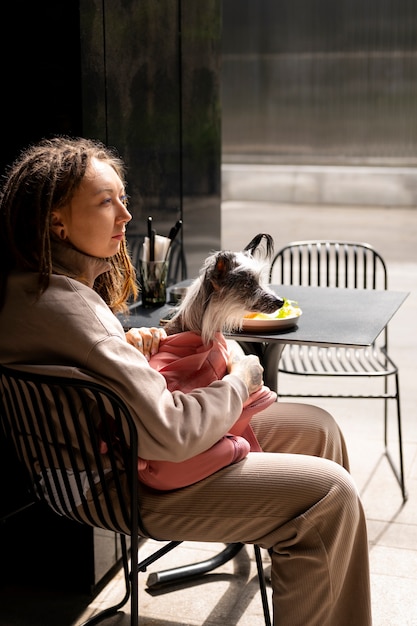 Photo gratuite vue latérale femme portant un chiot dans un sac