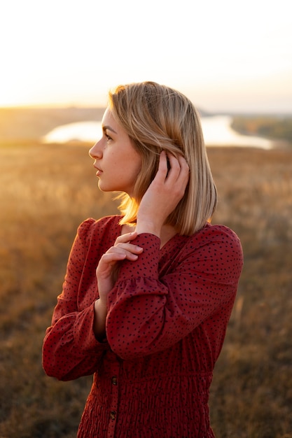 Vue latérale femme posant au coucher du soleil