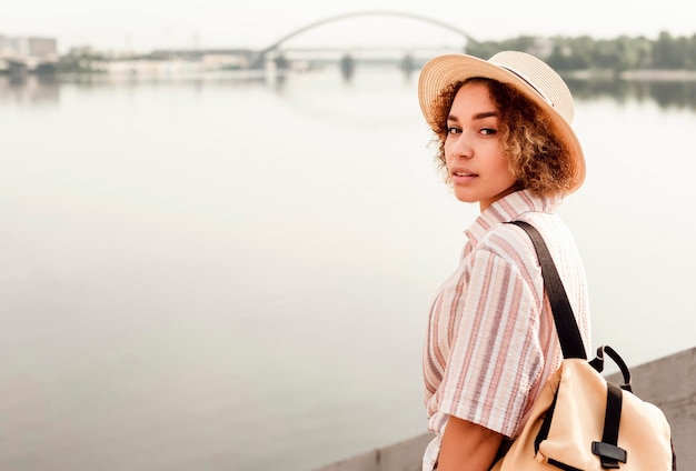 Vue latérale femme posant à côté d'une rivière