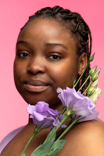 Vue latérale femme posant avec des fleurs